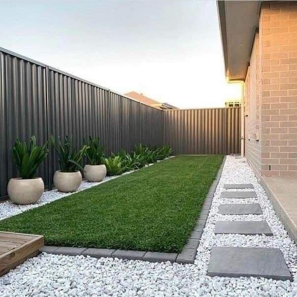 Landscaped yard with white stones and potted plants