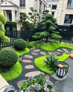 Landscaped garden featuring mossy ground cover, stepping stones, and ornamental trees, by MG Landscaping.
