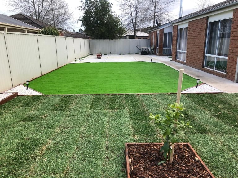Artificial grass installation in backyard.
